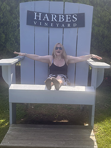 Anna relaxing in a giant Adirondack chair at a vineyard